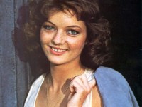 sarah_sutton_holding_jacket_over_shoulder_cropped