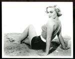 shirley_eaton_sitting_on_sand_looking_over_shoulder