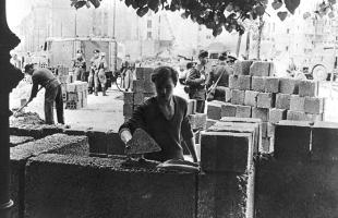 berlin_wall_1961_an_east_german_worker_lays_bricks_as_he_builds_the_walls