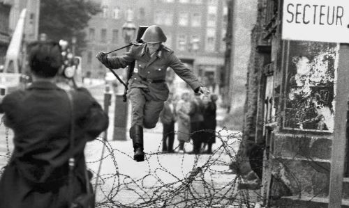 berlin_wall_1961_east_german_soldier_conrad_schumann_defects_by_jumping_over_barbed_wire_border_as_berlin_wall_is_built